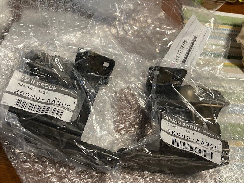 Nissan OEM Skyline R34 Headlamp Brackets Left & Right 26040-AA300 26090-AA300